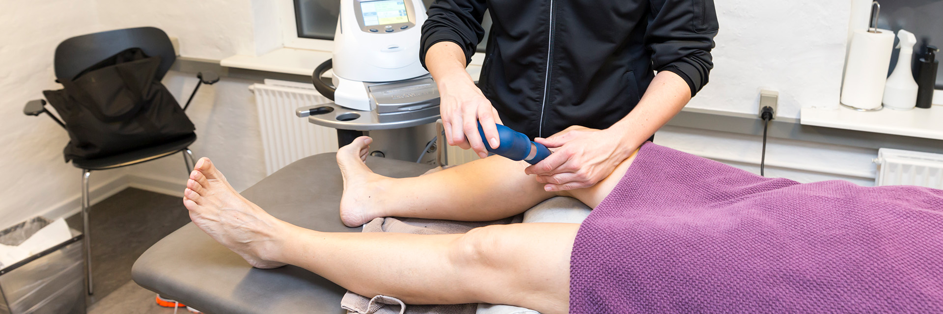 En af fysioterapeuterne ved Fysioterapeuterne Esbjerg ultralydsbehandler en klients knæ